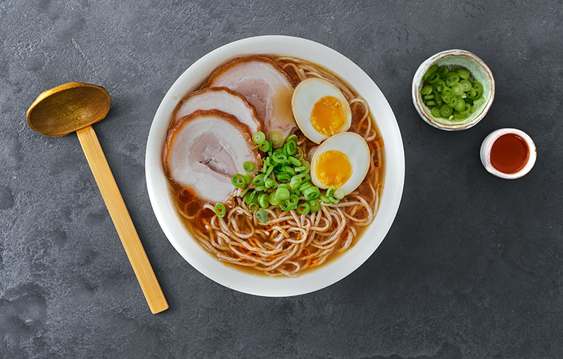 Ramen Tonkotsu soup topped with eggs and spring onions.